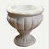Decorative stone urn on a textured surface with a blurred background