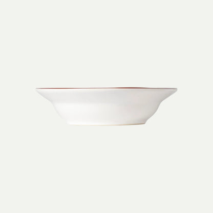 White ceramic bowl with a thin red rim on a white background