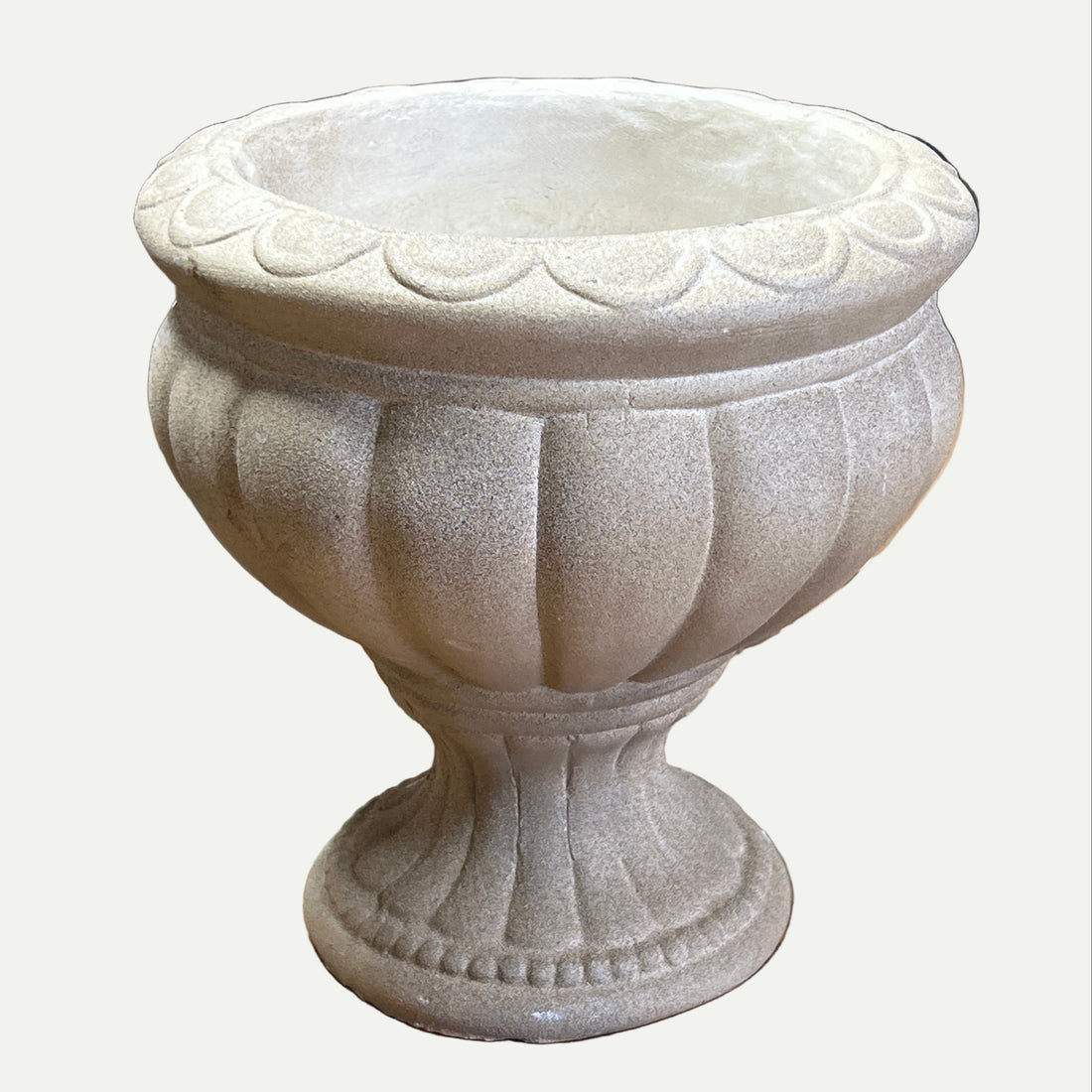Decorative stone urn on a textured surface with a blurred background