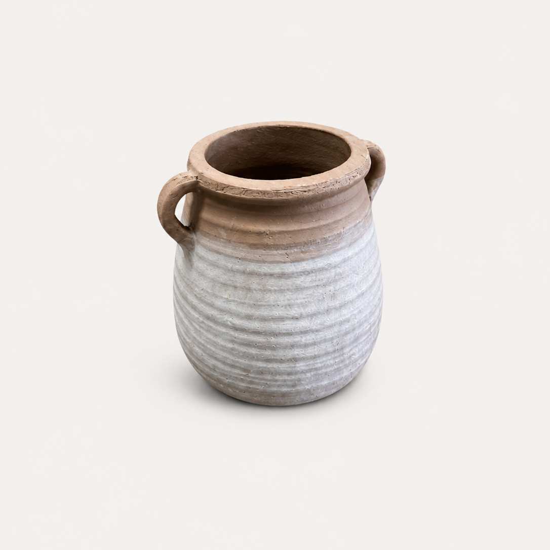 Ceramic vase with ribbed texture and two handles on a light beige background