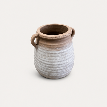 Ceramic vase with ribbed texture and two handles on a light beige background