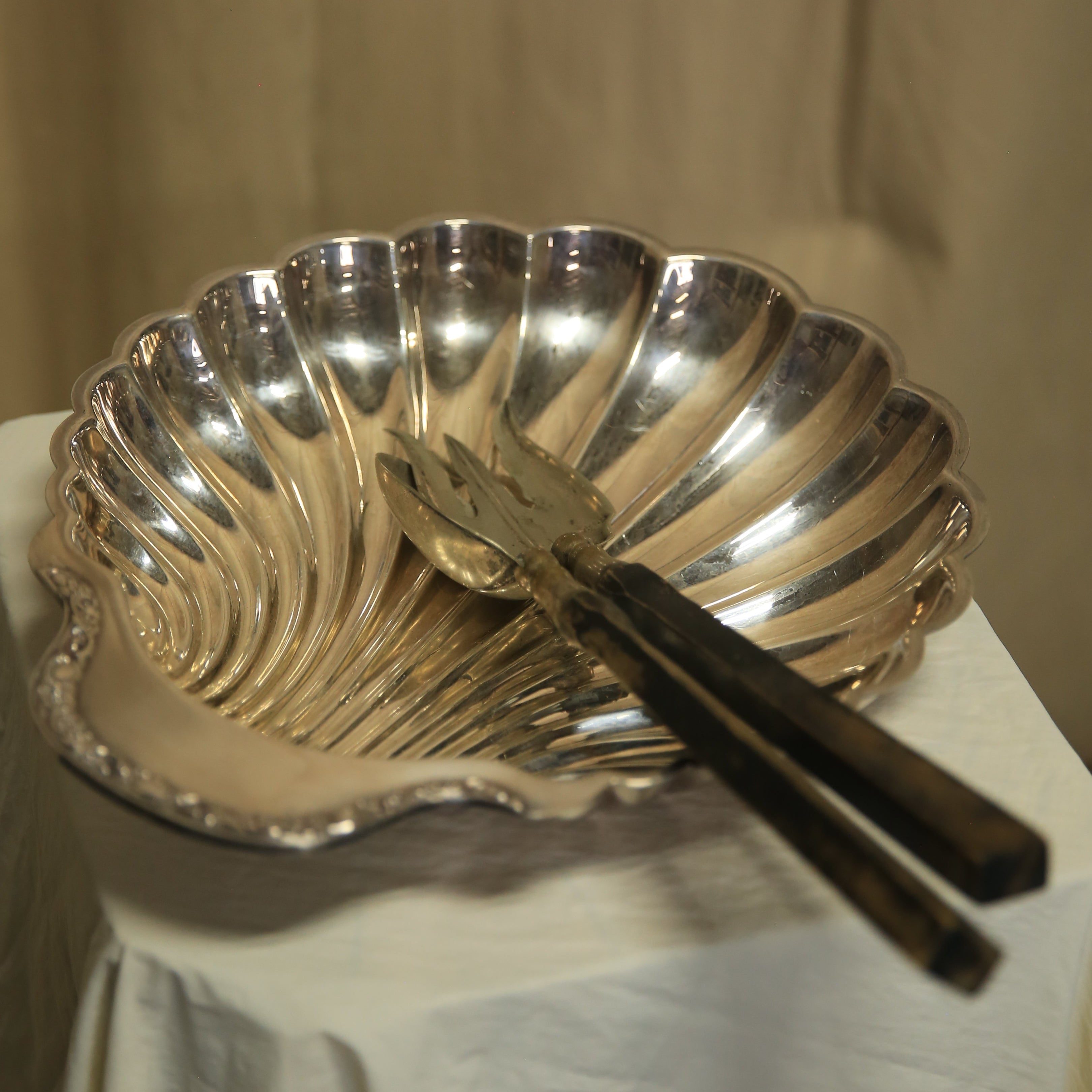 Silver cake server on a beige surface