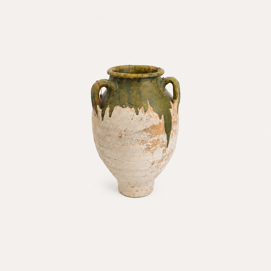 Vintage ceramic vase with green and beige glaze on a white background